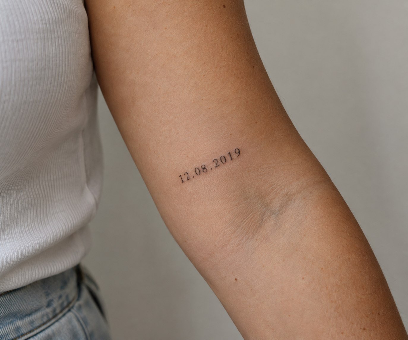 Small cluster of three fine-line star tattoos on the shoulder.