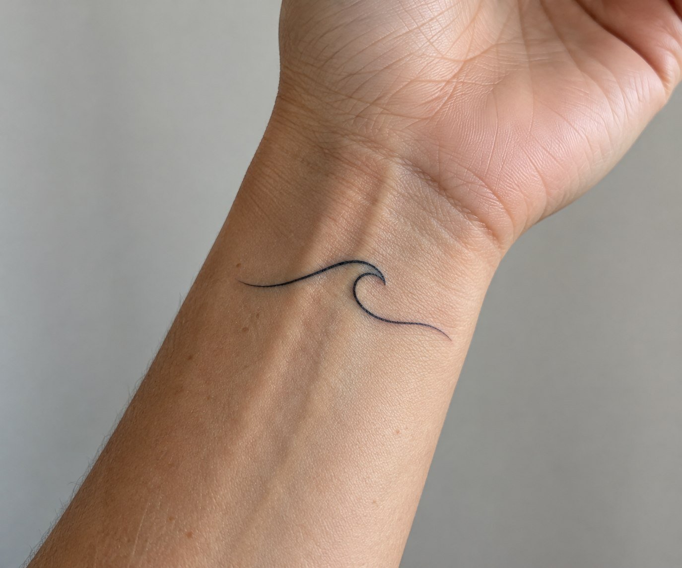 Delicate fine-script date tattoo on the inner arm.