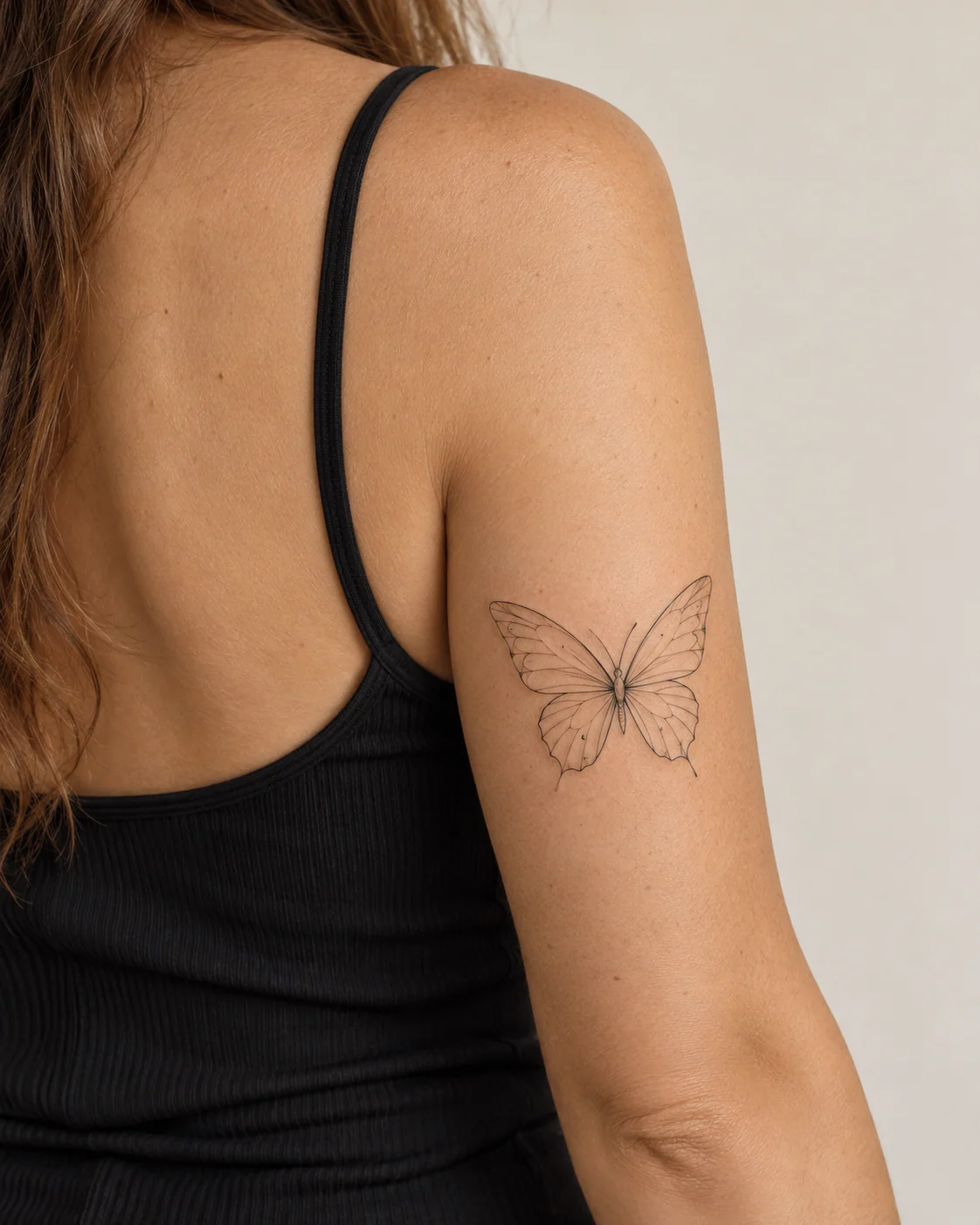Airy Butterfly on the Back of the Arm fine line tattoo concept on the back of upper arm