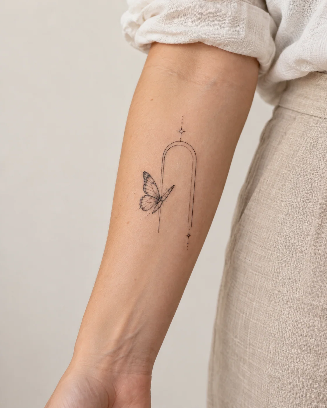 Butterfly with an Open Gate Shape fine line tattoo concept on the inner forearm