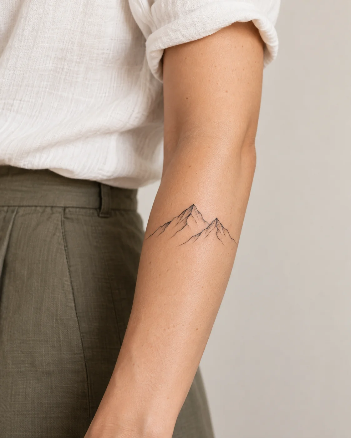 Simple Mountain Outline fine line tattoo concept on the outer forearm