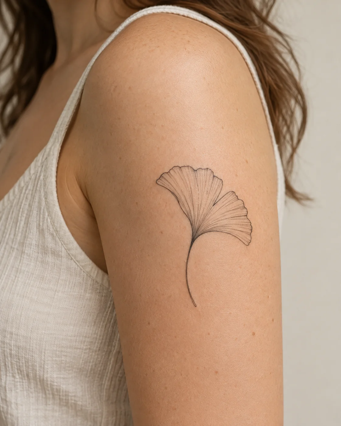 Ginkgo-Inspired Leaf fine line tattoo concept on the outer upper arm