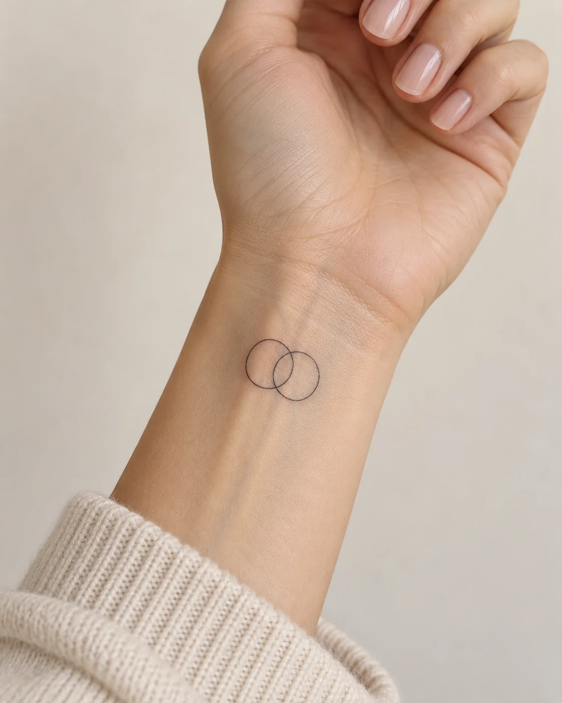 Two Interlocking Circles fine line tattoo concept on the inner wrist