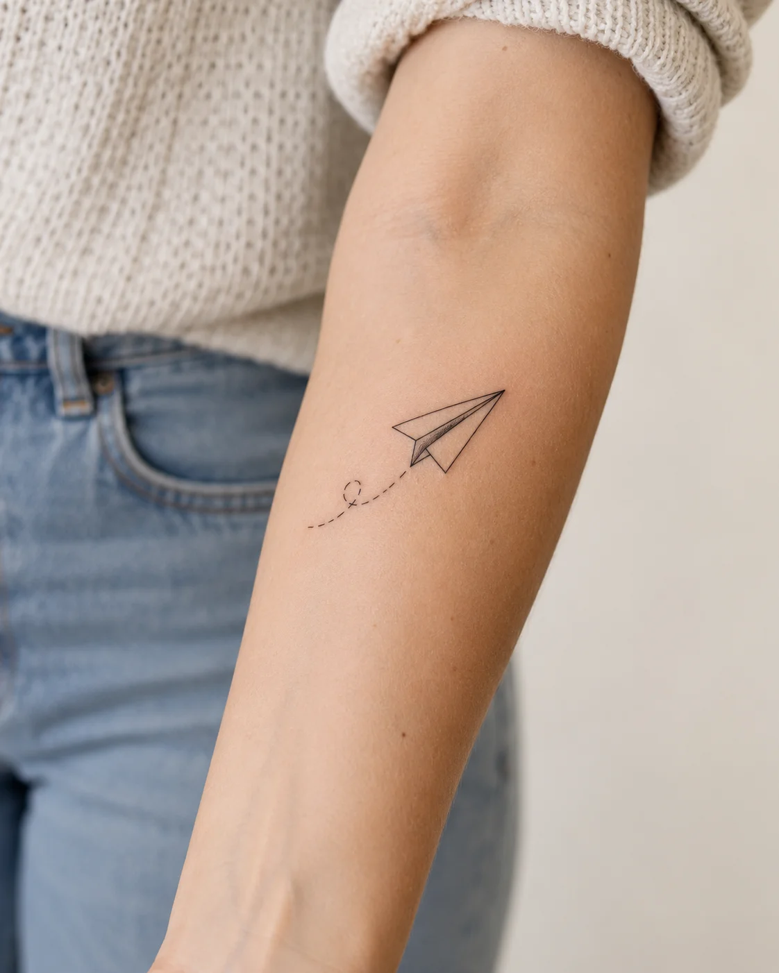 Fine Paper Airplane fine line tattoo concept on the inner forearm