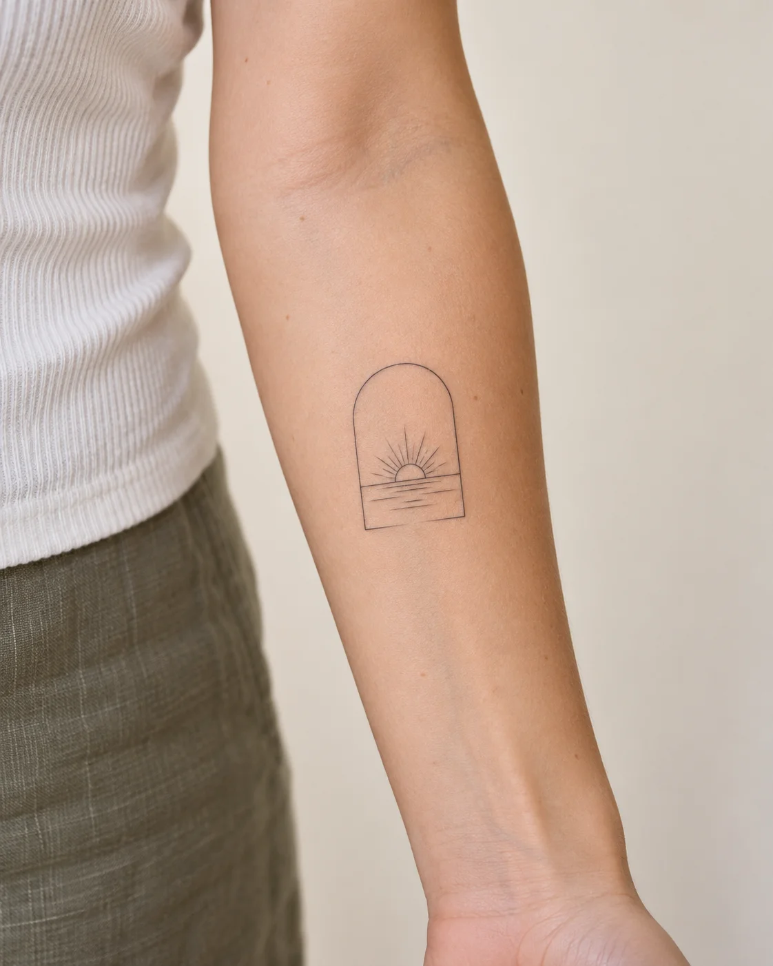 Tiny Sunrise Through an Arch fine line tattoo concept on the inner forearm