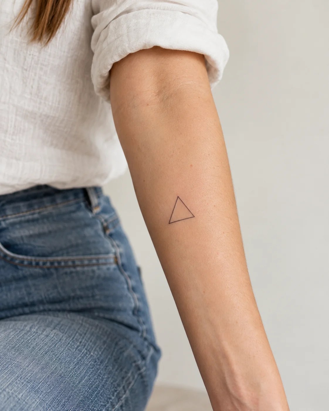 Fine Open Triangle fine line tattoo concept on the outer forearm