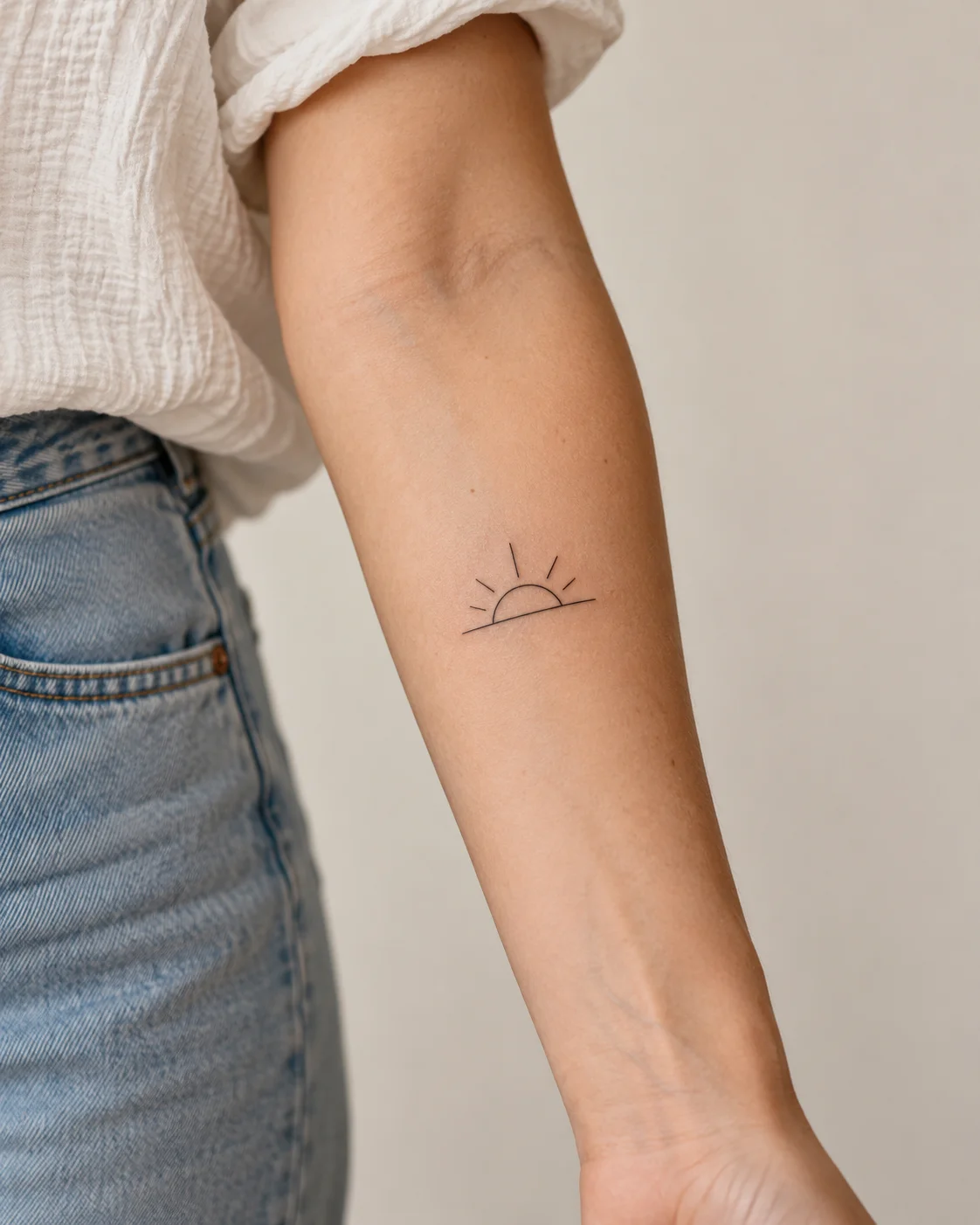 Small Sunrise fine line tattoo concept on the inner forearm